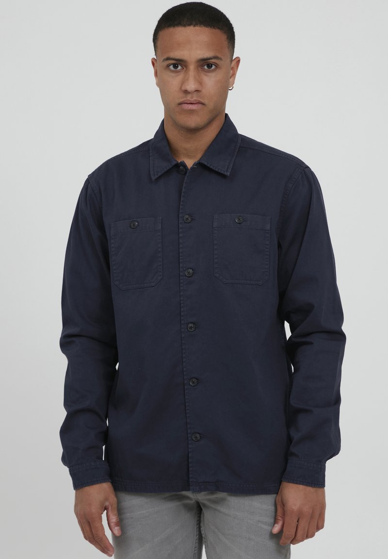 Camicia a maniche lunghe blu navy con bottoni, due tasche sul petto e colletto strutturato, realizzata in tessuto leggero.