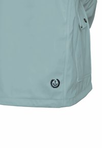 Light blue waterproof jacket with a smooth texture, featuring a black anchor logo on the hem and side pocket openings.