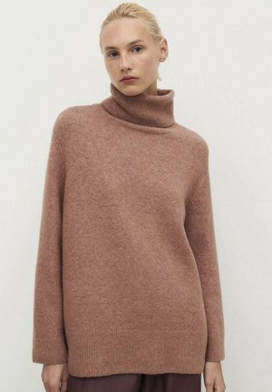 Rose-colored turtleneck sweater made from soft material. Features a loose fit with long sleeves and a ribbed cuff and hem.