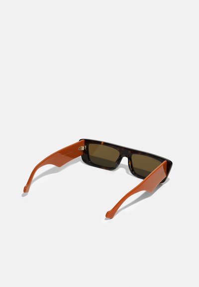 Occhiali da sole in tartaruga marrone con lenti scure. Le aste arancioni presentano una superficie liscia e un dettaglio di branding sottile, che evidenzia un design moderno.
