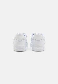 Sneaker bianche basse con materiale in pelle texturizzata, colli imbottiti e suola in gomma liscia; presenta il logo Vans in rilievo sul tallone.