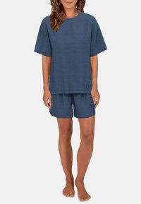 Weit geschnittenes, blaues Loungewear-Set aus weichem Stoff; besteht aus einem kurzärmeligen Oberteil und Shorts mit Logo-Akzent am Saum.