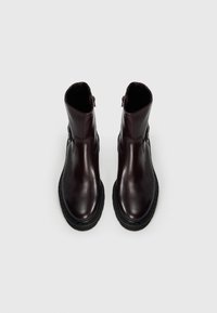 Bottines en cuir bordeaux avec une finition lisse, bouts ronds, fermetures à glissière latérales et semelles en caoutchouc noir texturé.