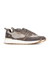 Zapatillas deportivas con una parte superior de tela y cuero marrón, con un patrón de malla. Suela blanca con una suela de goma de color caramelo y acentos metálicos.