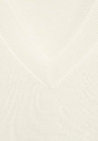 Maglione beige chiaro a scollo a V con un motivo a maglia testurizzata. Presenta un bordo a costine attorno al collo e un tessuto morbido per il comfort.