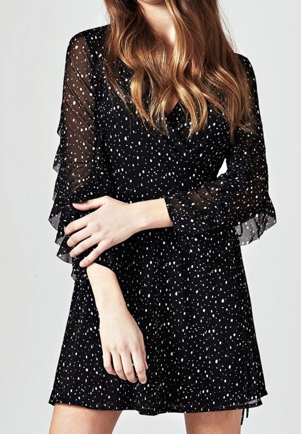 Schwarzes Kleid mit V-Ausschnitt, langen durchsichtigen Ärmeln und Rüschensäumen. Es hat ein gepunktetes Muster und einer lockeren Passform.
