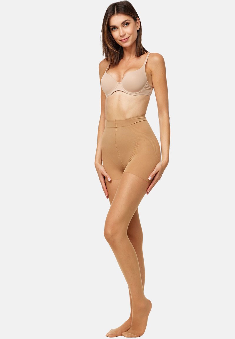 Shorts moldeadores sin costuras en color beige con una cinturilla alta, textura suave y acabado transparente. Combinados con un sujetador beige a juego.