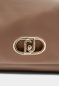 Borsa a mano in pelle marrone con logo in metallo color oro dal design intrecciato. Tessitura liscia con forma strutturata e linee pulite.