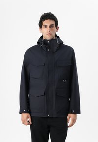 Marine vandtæt jakke med høj krave, justerbare snore, flere frontlommer og trykknapper. Glat tekstur og moderne design.