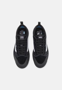 Černé tenisky Vans s vrchní částí z semiše a síťoviny, bílým bočním pruhem, černými šňůrkami, polstrovanou stélkou a smyčkou na patě.