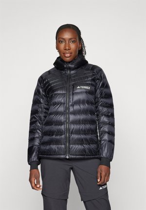 Black puffer jacket with a hood, quilted design, and zip closure. Features a logo on the chest and fitted cuffs. Soft, shiny texture.