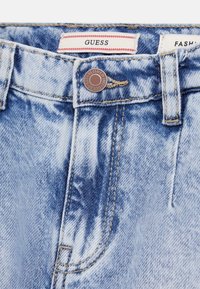 Jeans kratke hlače v svetlo modri barvi z izblidelo pranjem, z gumbom za zapiranje, šivanimi detajli in oznako blagovne znamke na pasu.