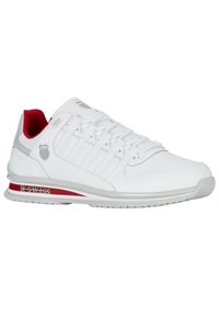 Białe buty sportowe z czerwonymi akcentami, syntetyczny wierzch, kontrastujące sznurowadła, wyściełana podeszwa oraz branding K-Swiss z boku.
