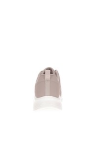 Sneaker color taupe chiaro vista da dietro, con una linguetta per il tallone e una suola bianca spessa e texturizzata su sfondo bianco.