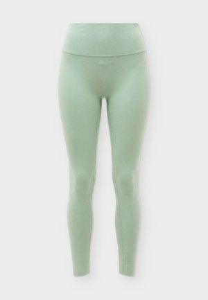 Lysegrønne sømløse leggings med høj talje og glat finish, vist mod en ensfarvet hvid baggrund.