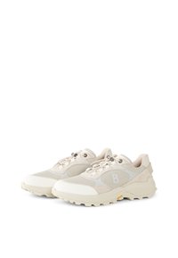 Footwear in light beige with mesh and suede elements, featuring a chunky sole and streamlined design. Reflective hardware detail included.