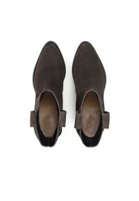 Botine din suede maro, cu vârful ascuțit și panouri laterale elastice. Au un toc mic și un detaliu sub formă de buclă la spate pentru a facilita încălțarea.
