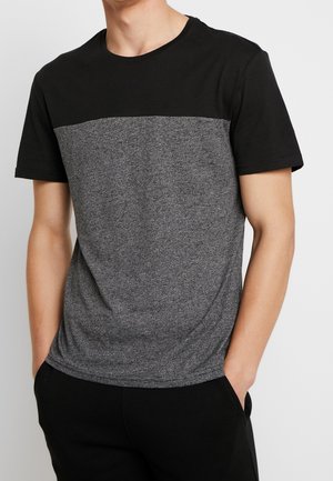 T-shirt à manches courtes avec une section supérieure noire et un corps en gris chiné. Fabriqué dans un matériau doux, avec un col rond et une coupe décontractée.