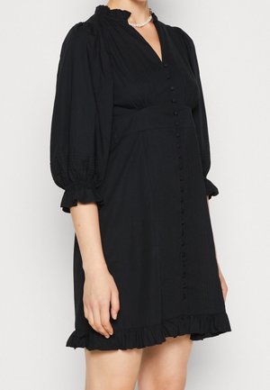 Black dress made of fabric, featuring a v-neck, puff sleeves, front buttons, and a ruffled hem. Smooth texture with pleated detailing.