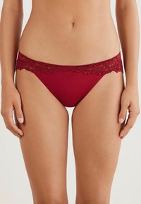 Bordeaux kant afgewerkte panties met een gladde stof, geschulpte rand en minimalistisch ontwerp, dat comfort en pasvorm benadrukt.