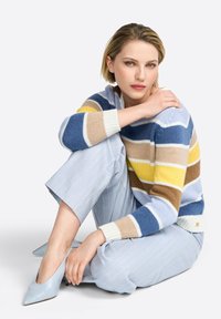 Striped sweater in blue, yellow, and brown hues; light blue pinstriped trousers; light blue pointed heels; smooth texture, casual fit.