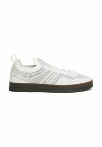Zapatilla de punto blanca con un upper flexible, diseño perforado, cuello elástico y suela de goma marrón, que cuenta con cordones y una lengüeta.