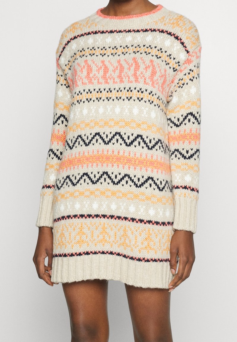 Abito maglione a maglia di colore crema con motivi multicolori. Presenta maniche lunghe, scollo rotondo e bordi a costine. I colori includono rosa, arancione e nero.