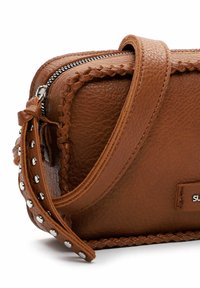 Borsa a mano in pelle marrone con superficie texturizzata, hardware in argento, bordo intrecciato e chiusura con zip. Include una tracolla removibile.
