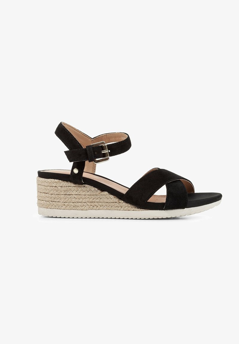 Sandales à talons compensés en daim noir avec des sangles croisées, boucle de cheville réglable et semelle intermédiaire en jute tressé. Semelle extérieure en caoutchouc plat pour une meilleure adhérence.