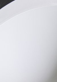 Tessuto bianco con una texture liscia e una leggera lucentezza, design curvo senza cuciture e un dettaglio nero sul bordo superiore.