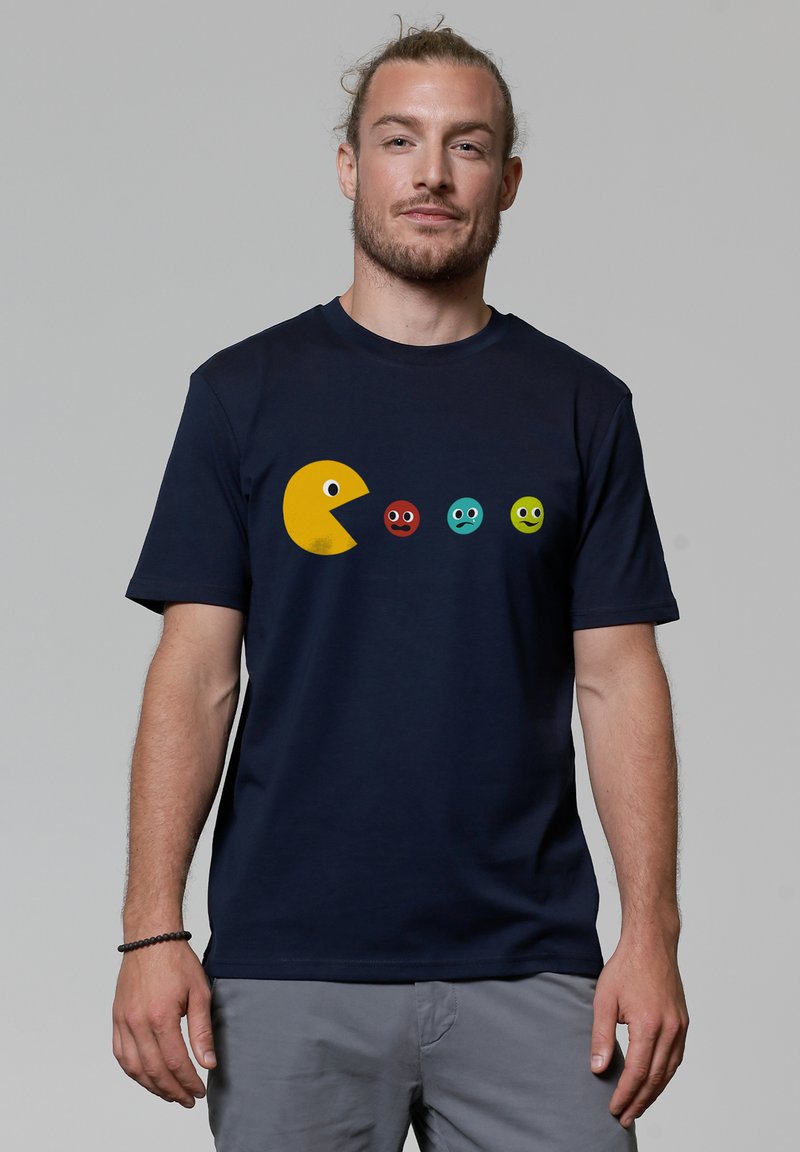 Navy-blaues T-Shirt aus Baumwolle mit einem gelben Pac-Man-Graphic und vier bunten Geistern in einer Reihe, die ausdrucksstarke Gesichtsdesigns aufweisen.