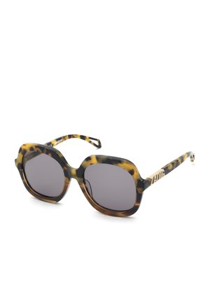 Lunettes de soleil carrées oversize à motif écaille de tortue, verres foncés et logo doré « ZADIG » sur les branches.