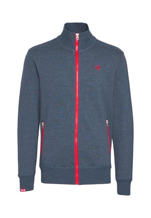 Donkerblauwe ritssluiting jas met een hoge kraag, rode rits en twee zijzakken met rits. Geribbelde mouwen en zoom met een klein logo op de borst.