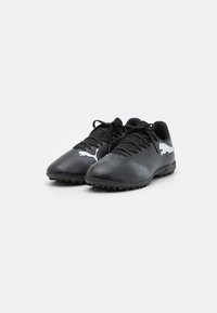 Botas de fútbol negras con una parte superior texturizada, cierre de cordones y un logo blanco en contraste en el costado. Cuentan con tacos de goma para tracción.