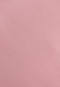 Nahaufnahme eines pinkfarbenen Stoffes mit diagonaler, gerippter Textur und dezentem Glanz.