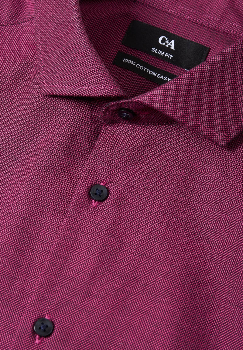 Slim fit, korte mouwen, bordeauxrode poloshirt van 100% katoen. Heeft een gestructureerd patroon en zwarte knopen met contrasterende stiksels.