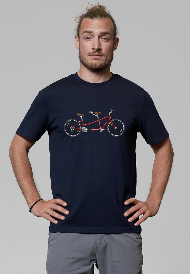Marineblauwe t-shirt met een afbeelding van een rode tandemfiets, gedetailleerd met zilveren accenten en bruine handvatten. Korte mouwen, ronde hals.