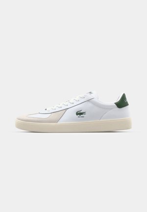 Witte leren sneakers met groene accenten, voorzien van een gestructureerde suède neuskap, vetersluiting en geborduurd logo op de zijkant.