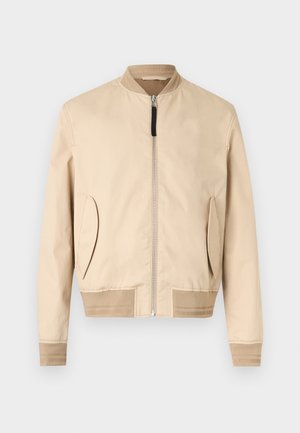 Beige bomberjack met ritssluiting aan de voorkant, geribde kraag, manchetten, zoom en schuine zakken aan de voorkant op een effen witte achtergrond.