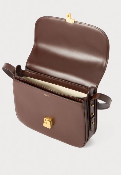 Sac en cuir marron avec un fermoir doré, design structuré, bandoulière réglable et intérieur doublé. Présente des accents dorés subtils sur le côté.