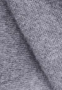 Prim-plan al unui țesut moale, gri, tricotat, evidențiind textura fină și pufosenia cu straturi suprapuse.