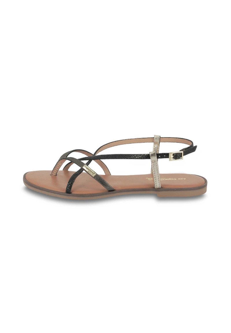 Sandalias planas con tiras negras y metálicas, que cuentan con una suave plantilla en tono bronce y un sutil diseño de tiras cruzadas; detalle de hebilla ajustable.