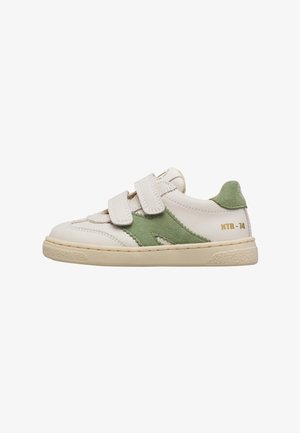 Witte lage sneaker met groene suède accenten, twee klittenbandbandjes, beige zool en "NTR-74" in goud gedrukt op de hiel.
