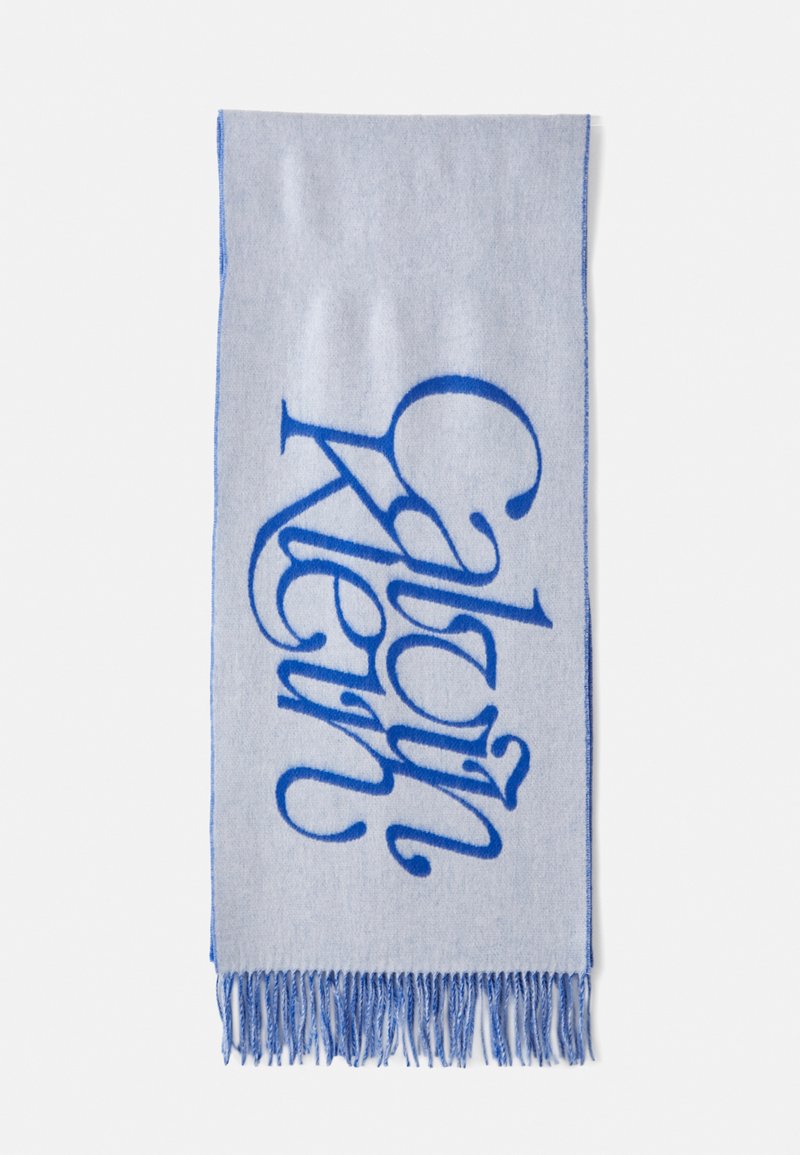 Lyseblåt tørklæde med et stort, fedt blåt kursiv logo og frynser i kanten. Blødt materiale med en glat overflade.