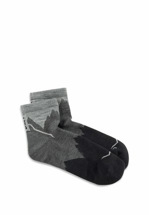 Par de calcetines gris y negro de longitud media con un patrón similar a montañas y detalles sutiles de líneas blancas sobre un fondo blanco.
