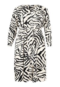 Ein Kleid mit Zebra-Print, das einen neutralen Hintergrund, schwarze Streifen, lange Ärmel, einen Wickelgürtel in der Taille und Faltendetails aufweist.