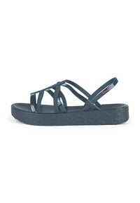 Dark blue sandals with a textured sole, featuring crisscrossing translucent straps and a flexible heel strap. Notable logo accent.