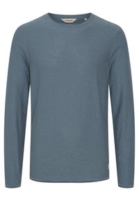 Męski niebieski sweter z długim rękawem i okrągłym dekoltem w rozmiarze medium, z małą metką z tkaniny blisko brzegu.
