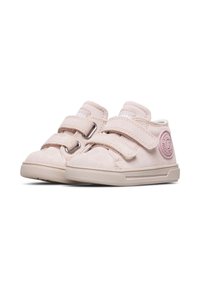 Scarpine per bambini in suede rosa con due cinturini in Velcro, punta tonda e suola in gomma. Presentano un distintivo circolare sul lato esterno.