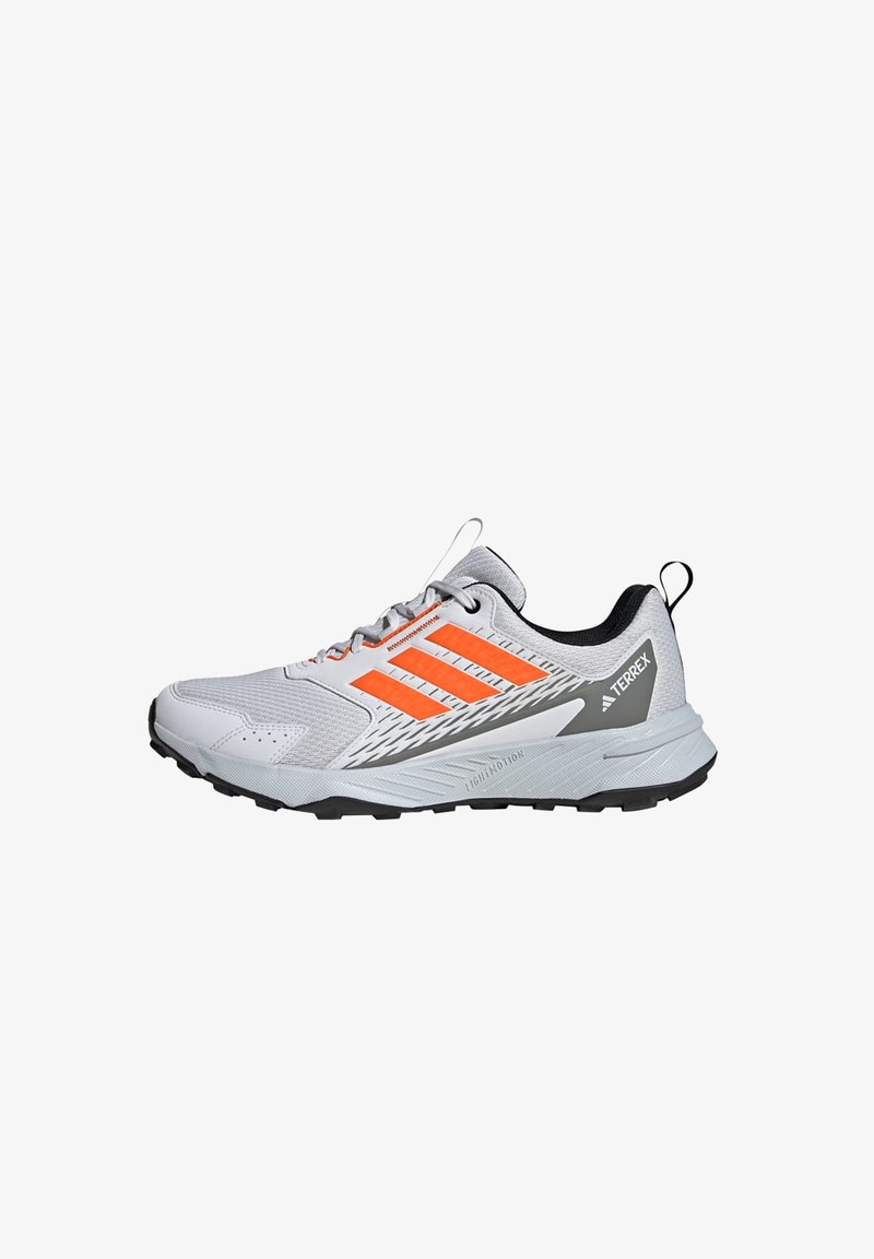 Graue Sportschuh mit orangefarbenen Akzenten und drei Streifen an der Seite. Strukturiertes Obermaterial mit schwarzem Innenfutter und robustem schwarzem Außensohle.
